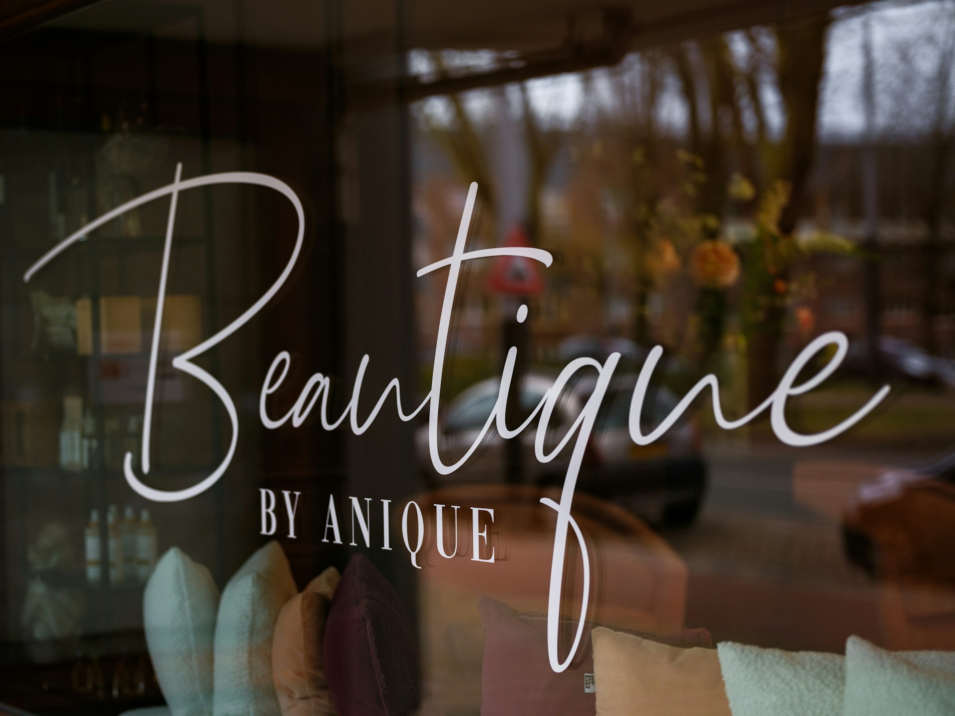 A close up of a glass window with the words beautique written on it